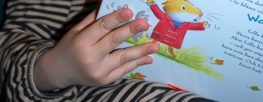 Bild på barnhand och bok